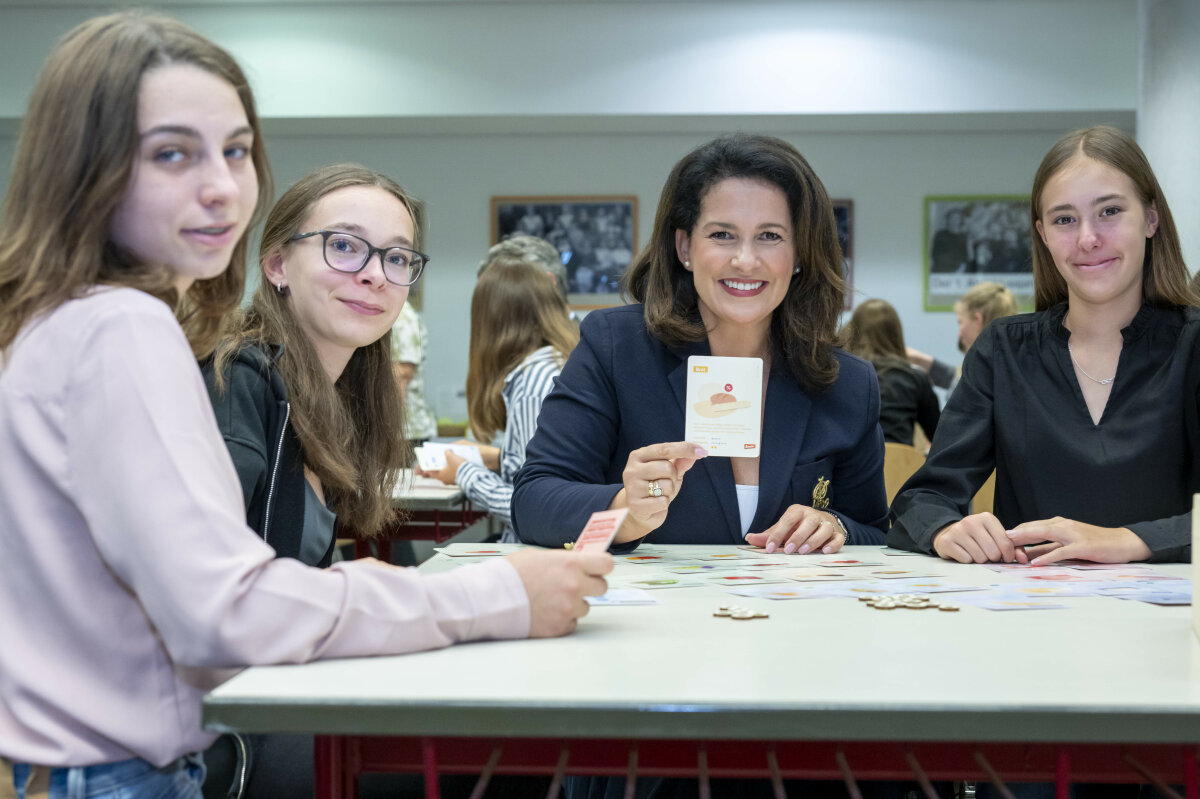 Staatsministerin Michaela Kaniber gemeinsam mit Schülerinnen der Franz von Assisi Realschule Freilassing beim Spiel mit dem Material der Lernkiste.