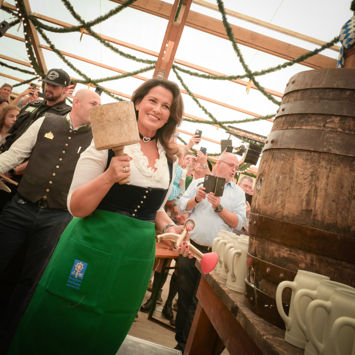 Das Bild zeigt die Staatsministerin kurz vor dem Anzapfen eines Bierfasses in einem Zelt auf der Oidn Wiesn.