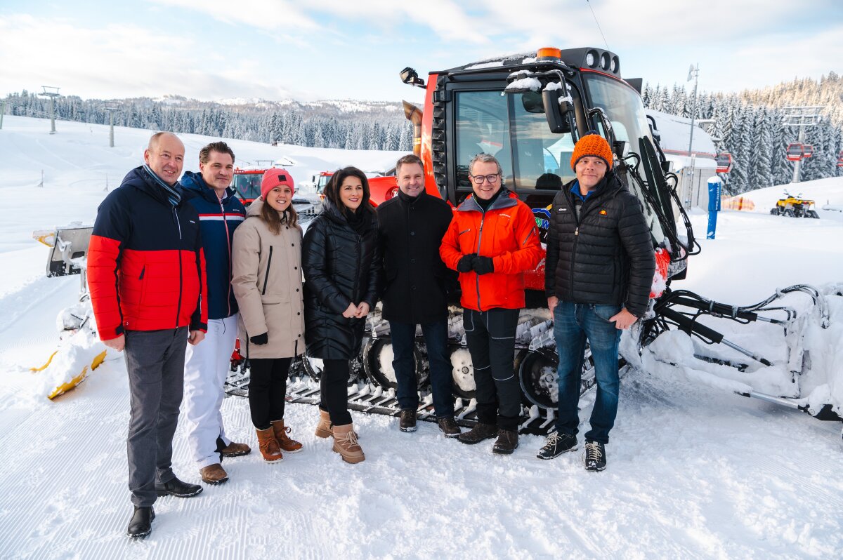 Tourismusministerin Michaela Kaniber in Mitten einer kleinen Personengruppe auf der tief verschneiten Winklmoosalm