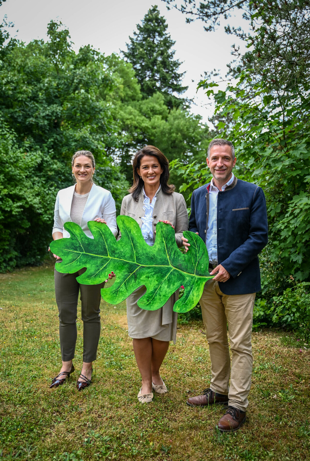 Das Bild zeigt Staatsministerin Kaniber mittig mit Gesundheitsministerin Gerlich zur linken sowie Landtagsabgeordnetem Schwab zur rechten. Sie halten zu dritt ein großes Blatt in der Hand..