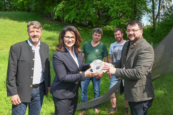 Landwirtschaftsministerin Michaela Kaniber (2. v. l.) lässt sich von Experten der Landesanstalt für Landwirtschaft den Falleninhalt einer Malaise-Falle erklären. Mit ihr wird das Vorkommen flugfähiger Insekten gemessen. Auf dem Bild ebenfalls zu sehen sind v. l. LfL-Präsident Stephan Sedlmayer, die Landwirte Norbert und Philipp Grenzebach sowie Sebastian Wolfrum (LfL).