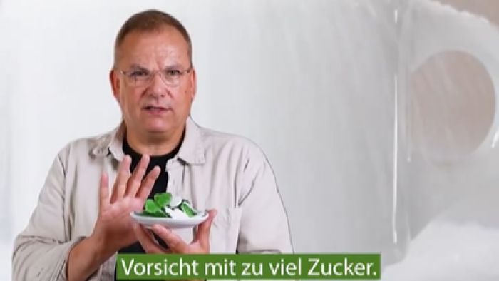 Ein Man hält einen kleinen Teller mit Fruchtgummis in der Hand