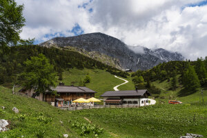 zwei Gebäude vor einer Wiese in den Bergen