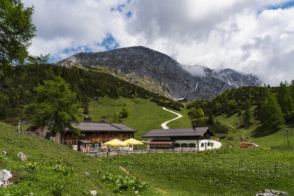 zwei Gebäude vor einer Wiese in den Bergen