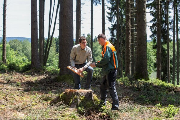 Förster und Waldarbeiter im Gespräch