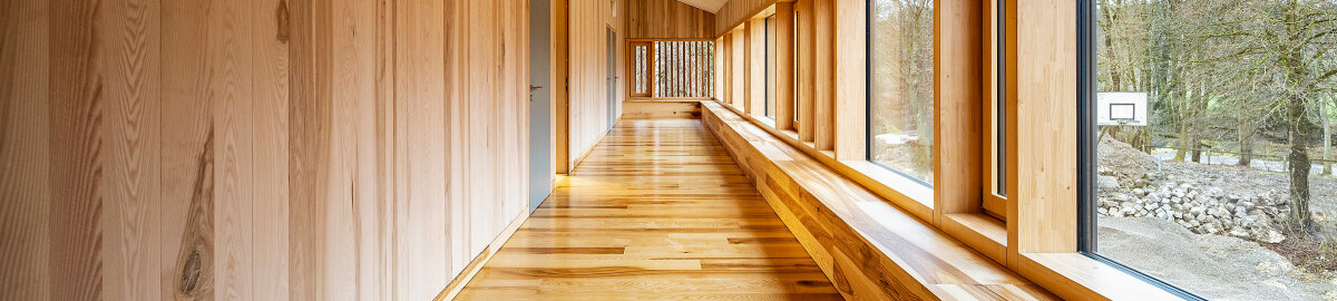 Aus Holz gebauter, moderner Flur mit großen Fenstern