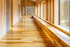 Aus Holz gebauter, moderner Flur mit großen Fenstern