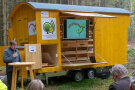 Waldarbeiterwagen "Waldhüpfer" mit geöffneten Seitenfächern und Sprecher mit Mikrofon