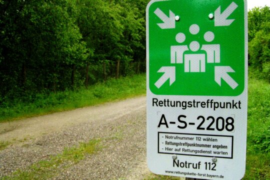 Schild eines Rettungstreffpunkts im Wald